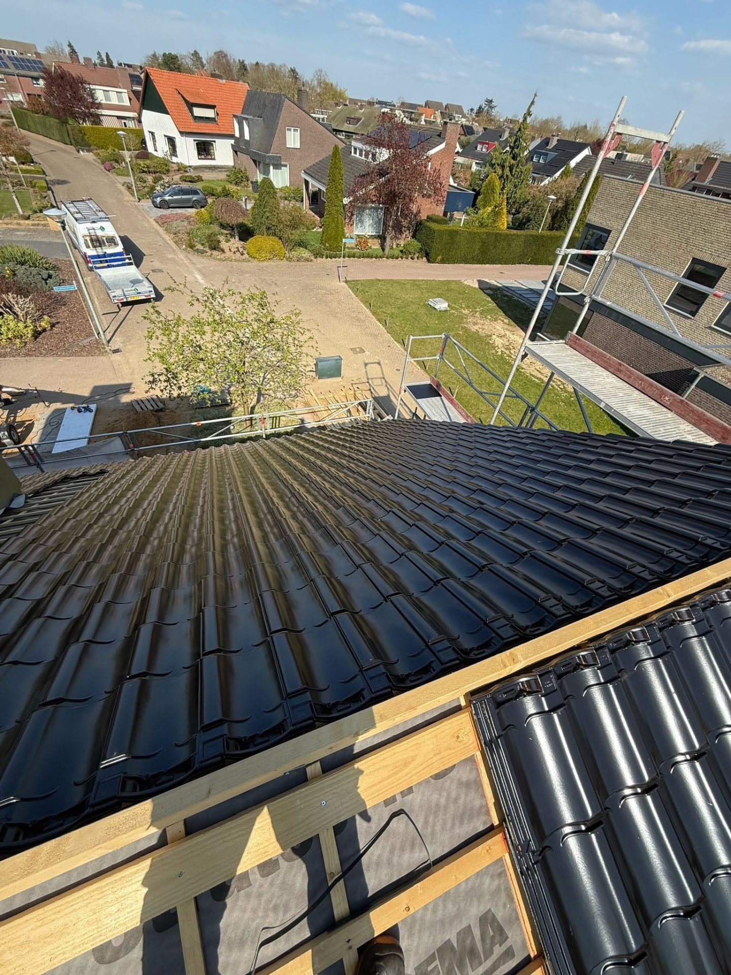 Nieuwe zwarte dakpannen tijdens dakrenovatie